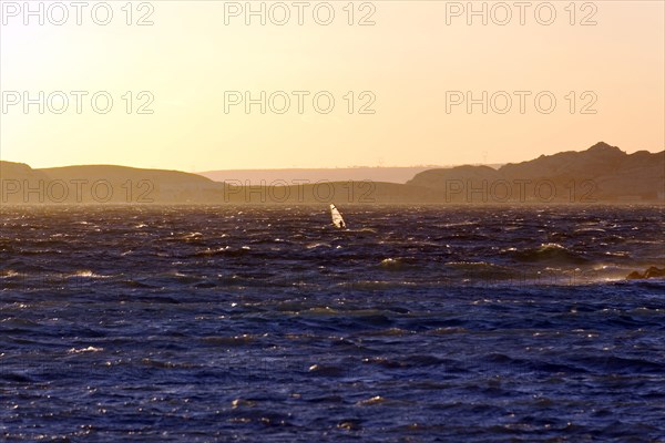 Marseille in the evening, A windsurfer glides over the ocean waves at sunset, Marseille,