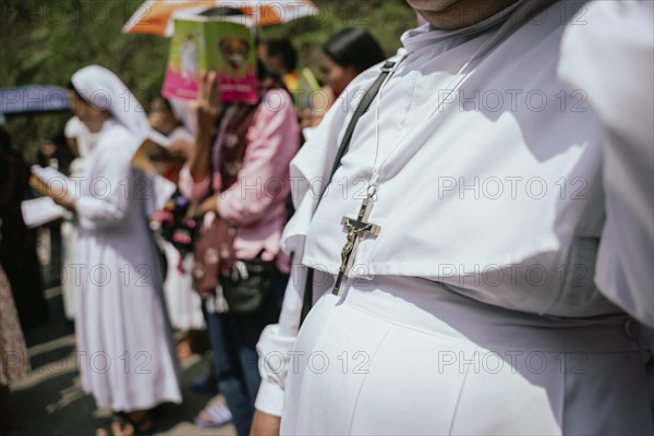 A nun wears a Cross as she recite prayers during a re-enactment of the crucifixion of Jesus Christ