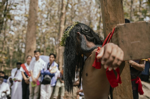 Christian devotees takes part in a perform to re-enactment of the crucifixion of Jesus Christ