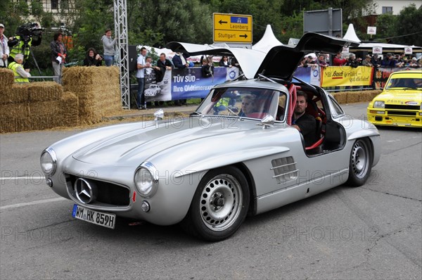 A silver Mercedes classic car with gullwing doors and starting number 417 at a festival, SOLITUDE