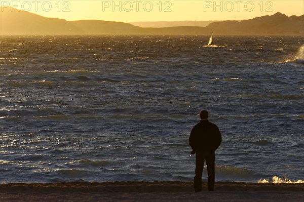 Marseille in the evening, A person stands on the shore and looks at the sea during sunset,