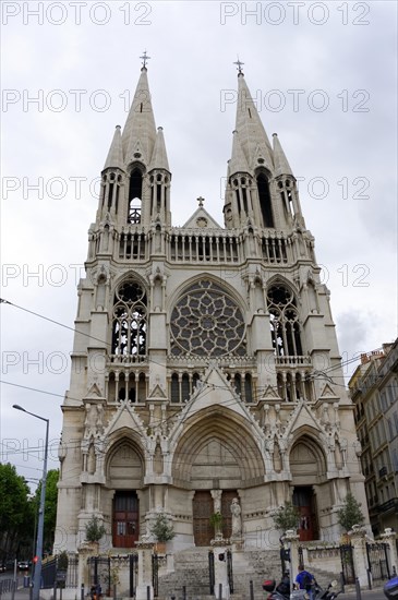 Church of Saint-Vincent-de-Paul, A Gothic church with twin towers rises in an urban setting,