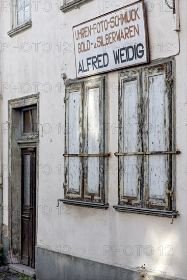 Closed shutters, abandoned photo shop with watch shop, jewellery, gold and silver, shop sign,