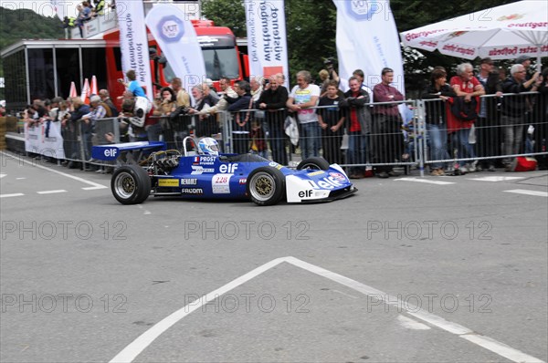 Blue racing car in the foreground with team and advertising banners in the background, SOLITUDE
