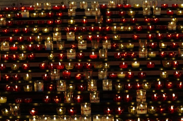 Church of Notre-Dame de la Garde with mosaics, Marseille, Many lit candles arranged in rows create