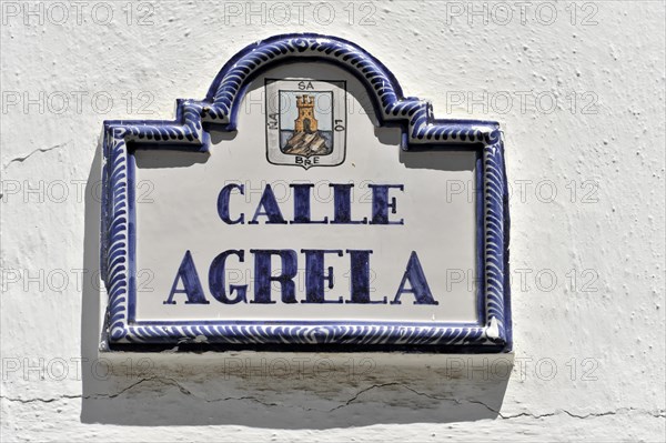 Solabrena, ceramic street sign with blue ornaments and heraldic coat of arms on a white wall, Costa