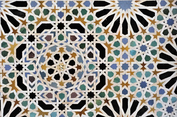 Artistic stone carvings, Alhambra, Granada, wall mosaic with complex geometric pattern in several