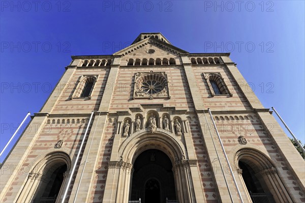 Speyer Cathedral, facade of a Romanesque church with a rose window and two towers against a clear