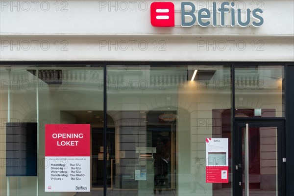 Office window showing opening hours of Belfius bank branch in the city Ghent, East Flanders,