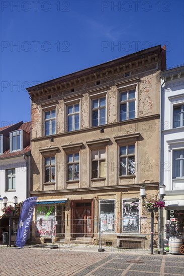 Dilapidated house in need of renovation with barriers in Lange Strasse, Greifswald,