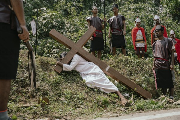 Christian devotees takes part in a perform to re-enactment of the crucifixion of Jesus Christ