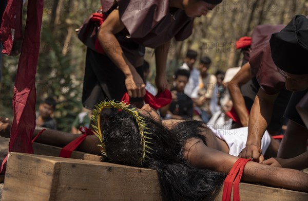 Christian devotees takes part in a perform to re-enactment of the crucifixion of Jesus Christ