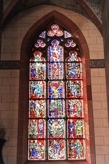 Speyer Cathedral, A detailed stained glass window in red and blue with biblical motifs floods the