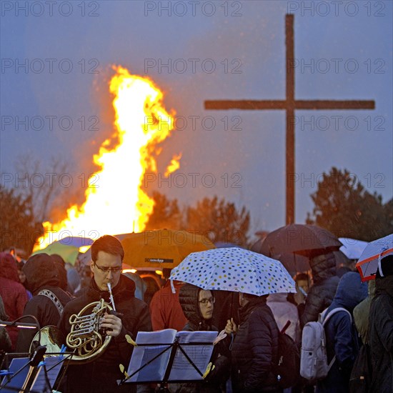 Musicians with a double horn in front of the Easter bonfire on the Haniel spoil tip with the summit