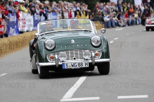 A green classic roadster drives on a road at a classic car race, SOLITUDE REVIVAL 2011, Stuttgart,