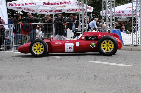 A red vintage racing car with sunshine and a driver in a yellow helmet, SOLITUDE REVIVAL 2011,