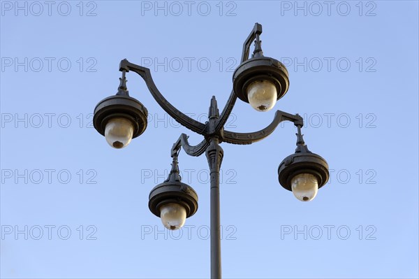 Historic-looking quadruple street lamp against a clear sky, Marseille, Departement