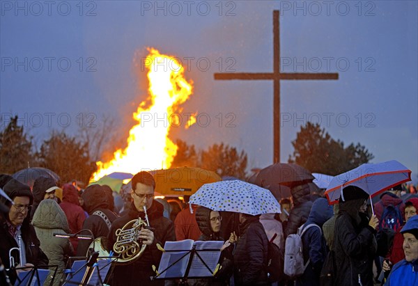 Musicians with a double horn in front of the Easter bonfire on the Haniel spoil tip with the summit