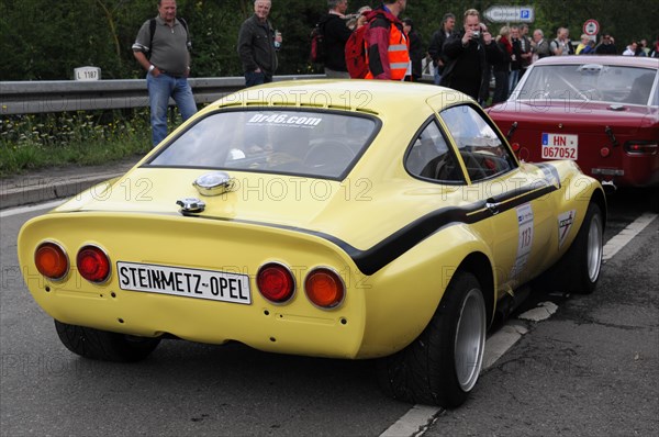 Rear end of a yellow vintage coupe with racing numbers and spectators, SOLITUDE REVIVAL 2011,