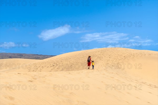 (Varios valores) Mother and son walking in the dunes of Maspalomas on vacation, Gran Canaria,