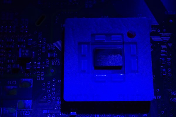 Close-up of blue lighted microchip on electronic computer circuit board, Studio Composition,