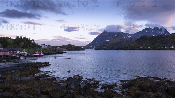 Landscape on the Lofoten Islands near Ramberg. On the left a few houses by the sea and a boat.