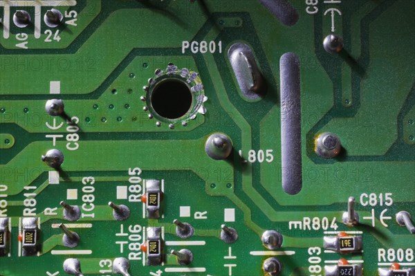 Close-up of green electronic computer circuit board with printed white numbers and letters and