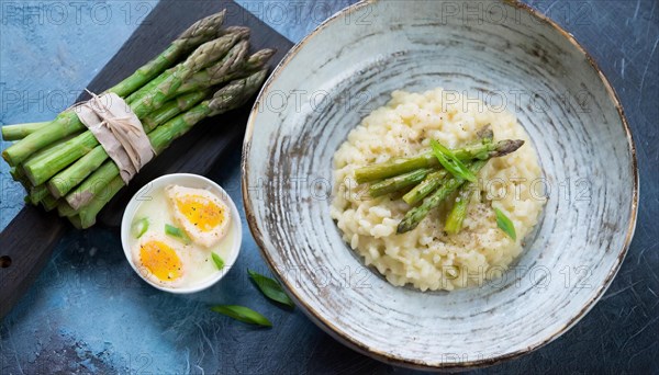 Creamy risotto with asparagus and a poached egg, served on wood, risotto with green asparagus, KI