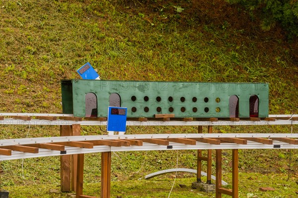 Close-up of a miniature railway track segment with circular holes and blue signs, in South Korea