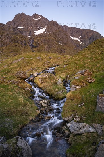 A torrent flows down the Stornappstinden mountain. Long exposure. At night at the time of the