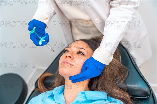 Elevated view of an unrecognizable female cosmetologist administering hyaluronic acid to the face