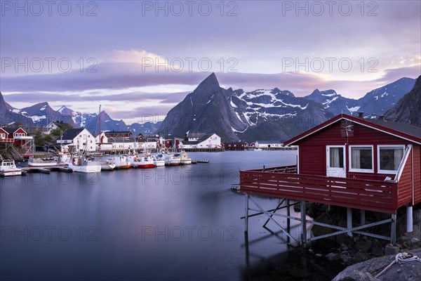 The village of Hamnoy. In the foreground, a typical red wooden house (rorbuer) on wooden stilts.