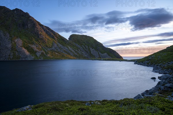 Lake Utdalsvatnet and the Hogskolmem mountain range. At night during the midnight sun in good