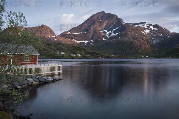 Landscape on the Lofoten Islands. A red wooden house in Kakern on Kakersundet. The mountain