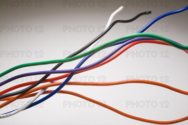Close-up of orange, red, green, blue, purple, white and black shielded electrical copper wires on