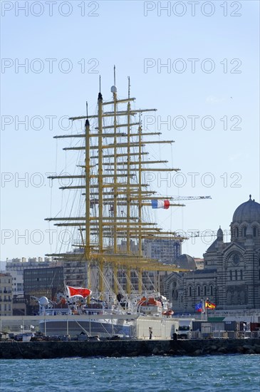 Marseille in the morning, Historic tall ship in the harbour in front of the city skyline under a