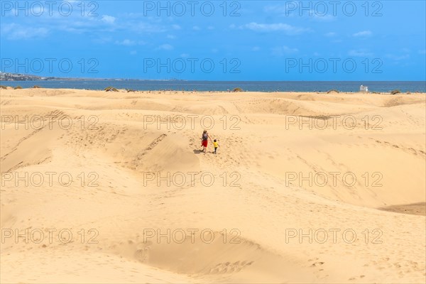 Mother and child walking on summer holidays in the dunes of Maspalomas, Gran Canaria, Canary