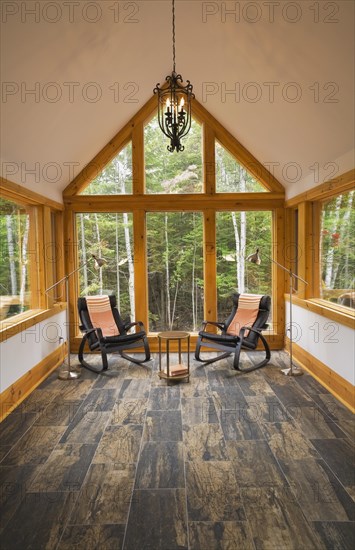 Reading room with tan and dark grey nuanced ceramic tile floor and two black leather rocking chairs