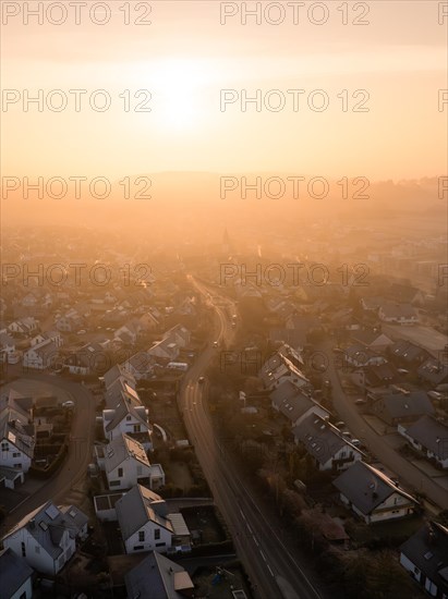 Sunrise casts a soft light on a town and its church towers in the distance, Gechingen, Black