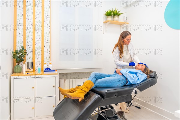 Cosmetologist working in a innovative beautician clinic injecting hyaluronic acid to the face of a