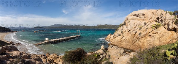 Rock formations, jetty leading into the sea, panoramic shot, Capriccioli beach, Costa Smeralda,