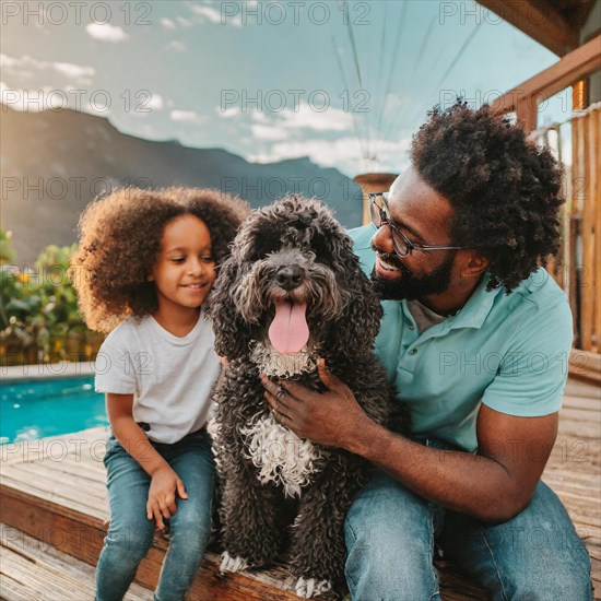 A man and a little girl are posing with a dog. The dog is wagging its tail and the girl is smiling.