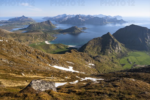 Landscape with sea and mountains. Descent from Himmeltindan mountain. View of the light-coloured