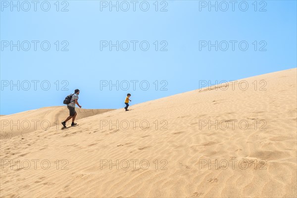 Father and son very happy in the dunes of Maspalomas, Gran Canaria, Canary Islands