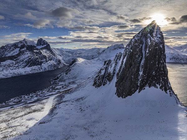 Aerial view of Bergen by the sea, fjord, sunbeams, winter, snow, Mount Segla, Senja, Troms, Norway,