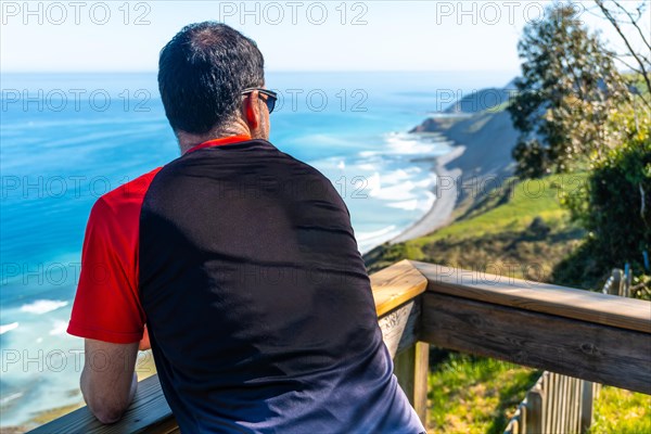 A tourist looking at the beautiful coastal landscape in the flysch of Zumaia, Gipuzkoa. Basque
