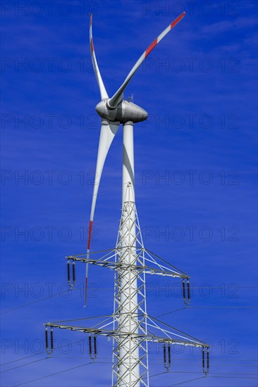 Electricity pylon with high-voltage lines and wind turbine at the Avacon substation Helmstedt,