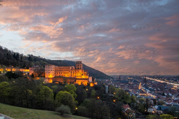 View over an old town with castle or palace rune in the evening at sunset. This town lies in a