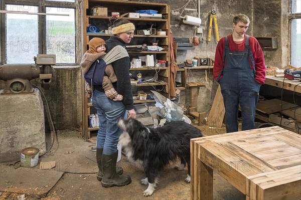 Family inspecting the table built by their son in the workshop, Mecklenburg-Vorpommern, Germany,