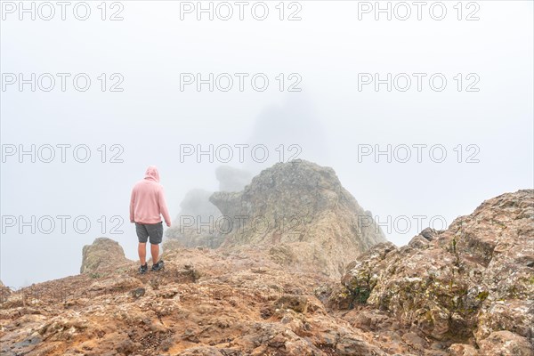 A tourist inside the fog on the very cloudy Pico de las Nieves in Gran Canaria, Canary Islands.
